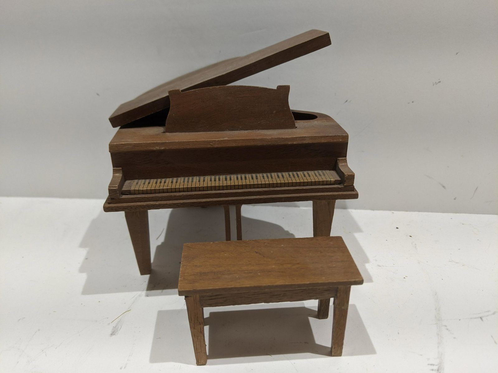 StromBecker Playthings Walnut Grand Piano & Bench: StromBecker Playthings Walnut Grand Piano & Bench. Measurements in inches: 4 high x 4 1/2 x 5 Condition:One leg has been reglued Shipping:We offer in-house shipping. Item(s) will be packed after invoi