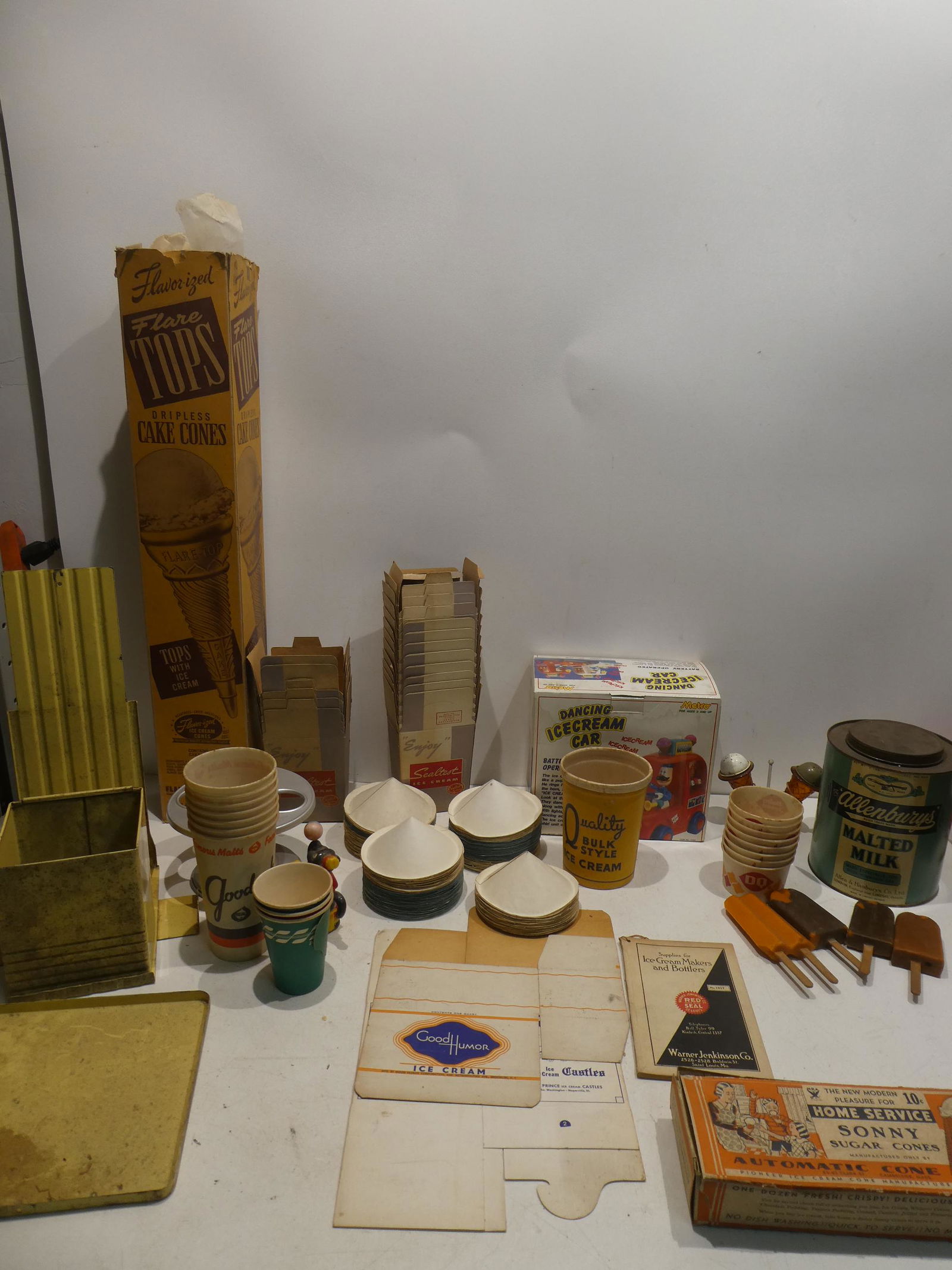 Large Lot Vintage Ice Cream Shoppe Items: Large Lot Vintage Ice Cream Shoppe Items including paper cones, tin car, cone dispenser, malted milk in tin, salt & pepper shakers, display ice cream bars and more. Condition:As found, shows dirt and