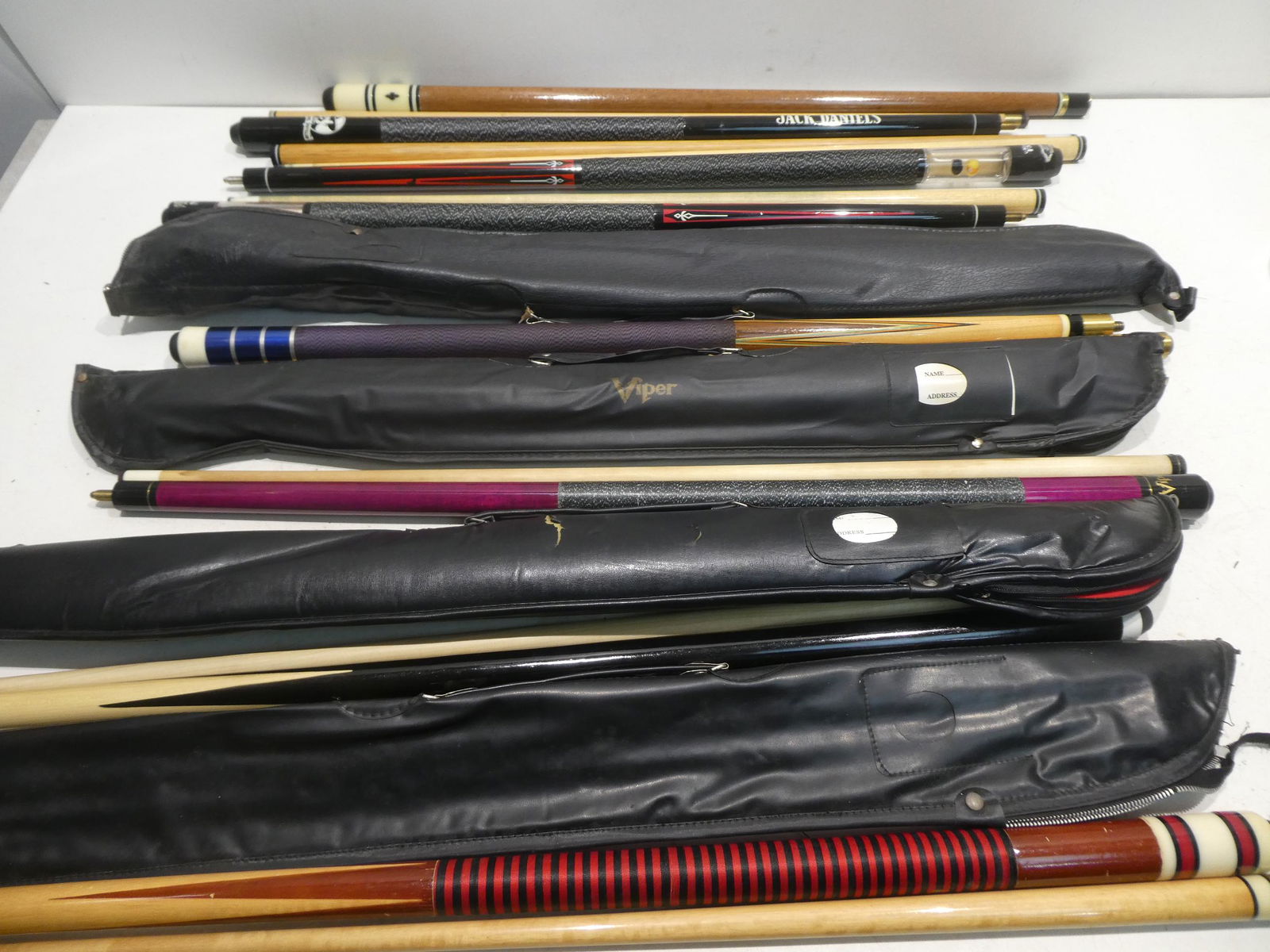 Lot 8 Pool Cue Sticks w/ Cases: Lot 8 Pool Cue Sticks w/ Cases including Jack Daniels, Minnesota Fats, Viper and more. Condition:Normal wear with age and use Shipping:We offer in-house shipping. Item(s) will be packed after invoice