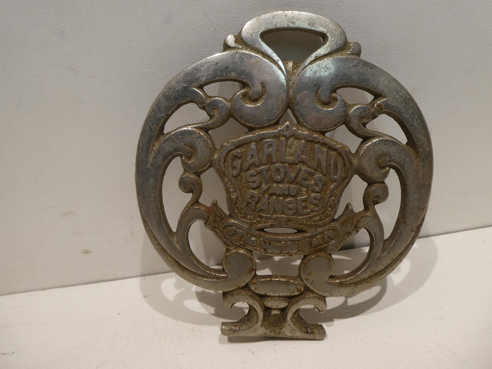 Antique Nickel Plated Cast Iron Garland Stove Nameplate: Antique Nickel Plated Cast Iron Garland Stove Nameplate. Measurements in inches: 7 1/4 x 8 1/4 Condition:Some wear with age and use Shipping:We offer in-house shipping. Item(s) will be packed after in