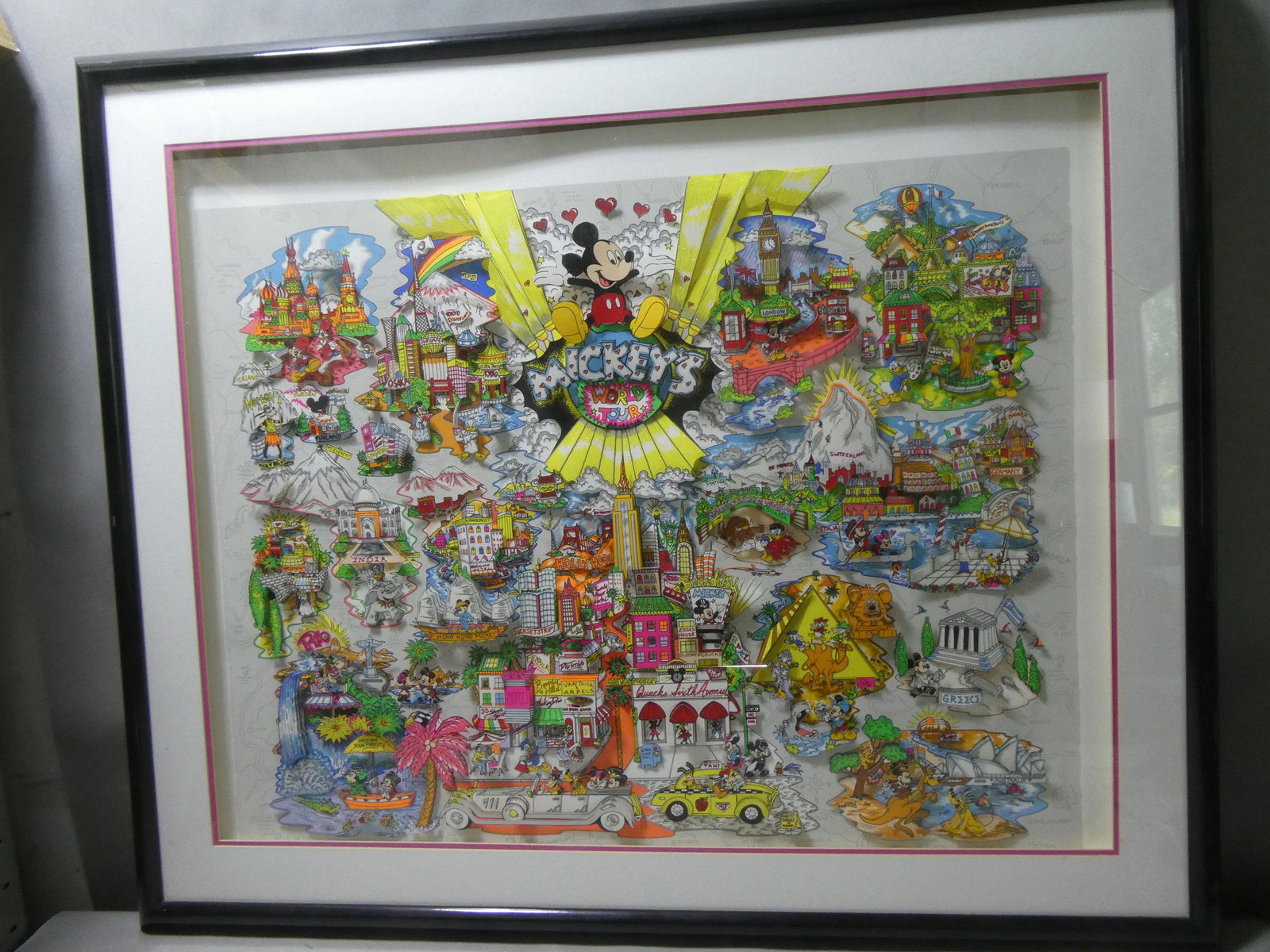 1996 Charles Fazzino Ltd Ed 3-D Mickey's World Tour: 1996 Charles Fazzino Ltd Ed 3-D Mickey's World Tour framed under plexiglass. Includes certificate of authenticity. Measurements in inches: 46 x 38, image: 36 x 28 Condition:Plexiglass has a scratch in