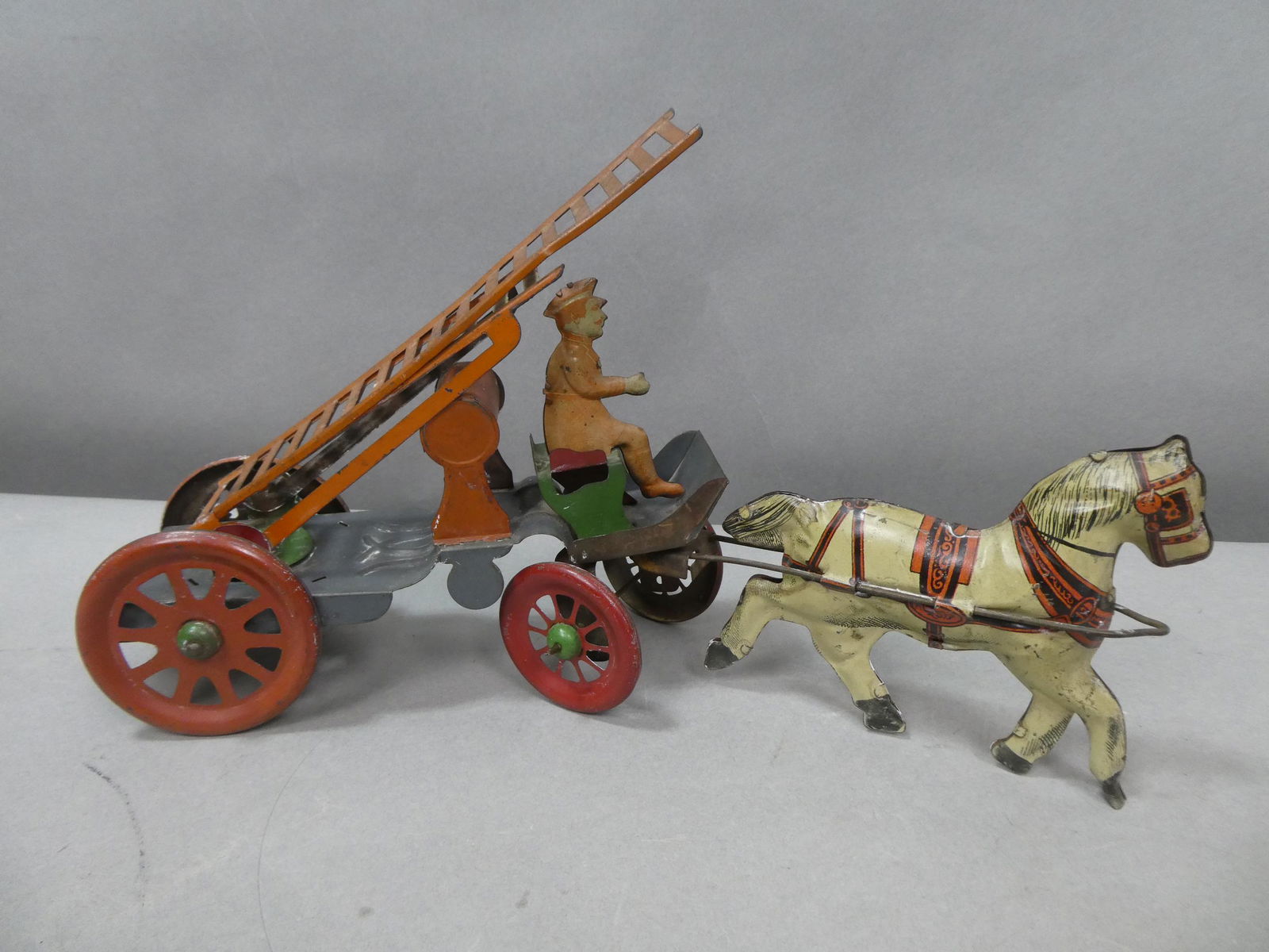 Antique Tin Litho Horse Drawn Ladder Fire Truck: Antique Tin Litho Horse Drawn Ladder Fire Truck. Measurements in inches: 14 long Condition:Has light wear and fading to colors Shipping:We offer in-house shipping. Item(s) will be packed after invoice