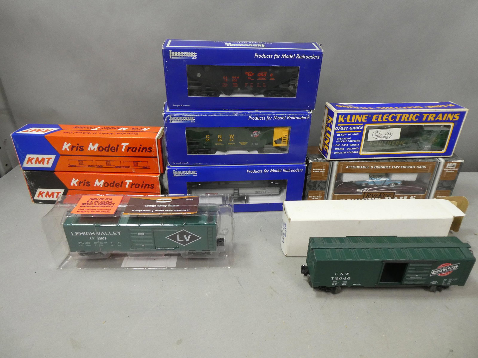 Lot 9 Vintage Assorted Train Cars in Boxes KMT K-Line: Lot 9 Vintage Assorted Train Cars in Boxes Including KMT Boxcars, K-lIne Boom Car, Rail King Flat with Road Legends 1957 Chevy and Industrial rail coal car, tanker and coal car. Condition:Normal wear 