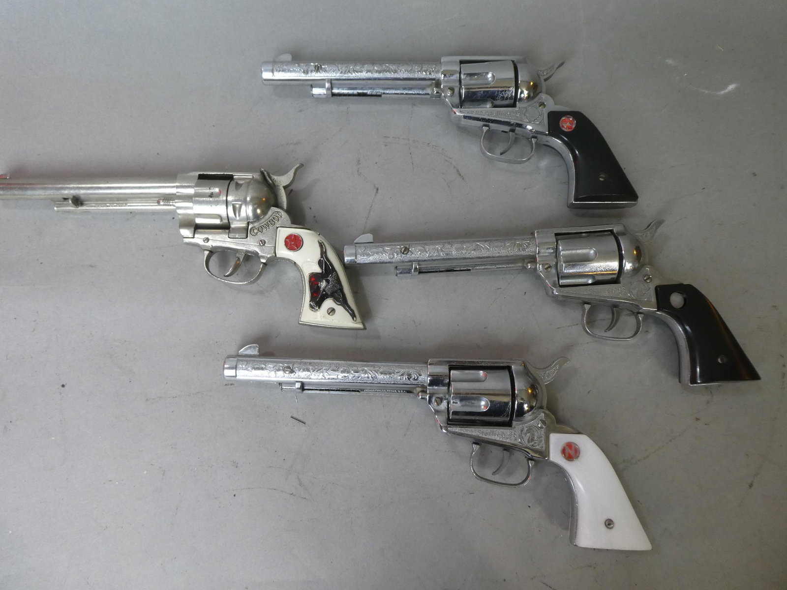 3 Nichols Stallion 45 & Cowboy Cap Guns: 3 Nichols Stallion 45 & Cowboy Cap Guns. Measurements in inches: around 11 long Condition:Normal wear with age and use. Missing N badge on one and other 45 does not fire Shipping:We offer in-house shi