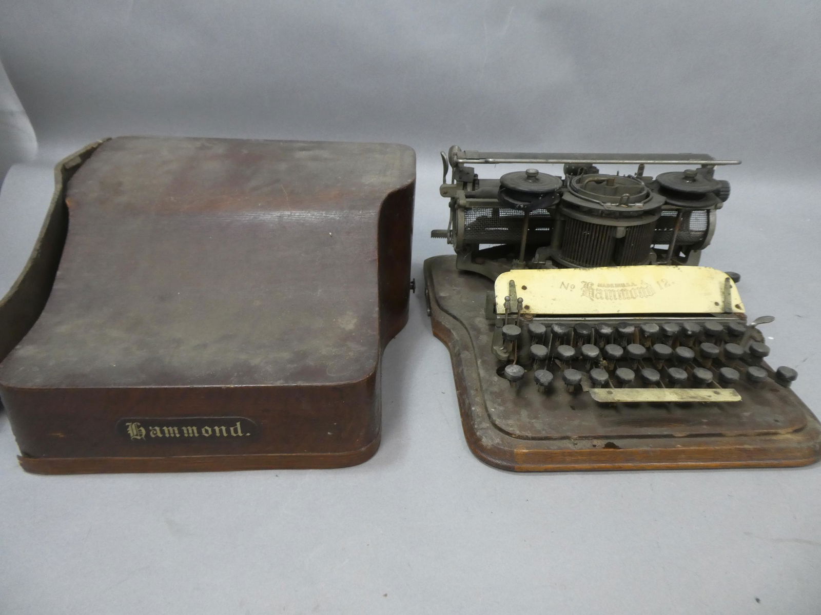 Antique 1912 Hammond No 12 Typewriter in Oak Case: Antique 1912 Hammond No 12 Typewriter in Oak Case. Measurements in inches: 8 high x 14 x 15 Condition:As found, needs a good cleaning and going over. One side of case is broken Shipping:We offer in-ho