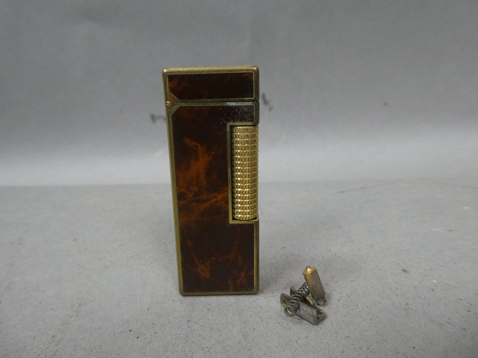 1950's Faux Wood & Gold Dunhill Lighter 24163: 1950's Faux Wood & Gold Dunhill Lighter 24163. Condition:Not working, need work with parts included Shipping:We offer in-house shipping. Item(s) will be packed after invoice is paid and shipping charg