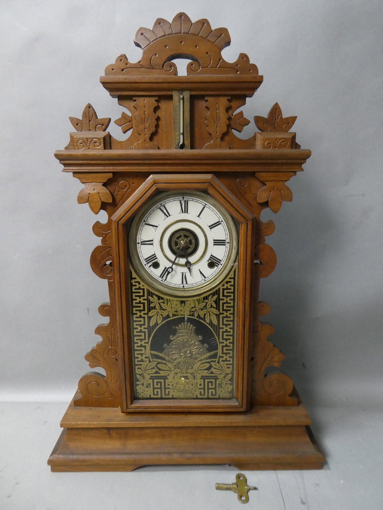 Antique Walnut Wood Regulator Mantel Clock: Antique Walnut Wood Regulator Mantel Clock with pendulum and key. Measurements in inches: 25 high x 16 x 5 Condition:Normal wear with age and use Shipping:We offer in-house shipping. Item(s) will be p