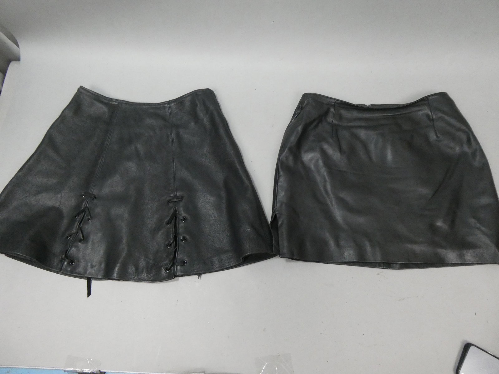Lot 2 Black Leather Skirts Size 10 & 12. Hugo Buscati: Lot 2 Black Leather Skirts Size 10 & 12. One made in USA and the Hugo Buscati. Measurements in inches: size 10, 18 long and size 12, 16 long Condition:Looks little if ever used Shipping:We offer in-ho