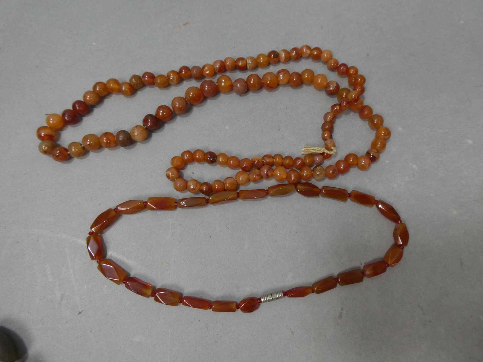 Early Pair Red Agate Carnelian Beaded Necklaces: Early Pair Red Agate Carnelian Beaded Necklaces. Measurements in inches: 16 and 32 long Condition:Normal wear with age and use Shipping:We offer in-house shipping. Item(s) will be packed after invoice