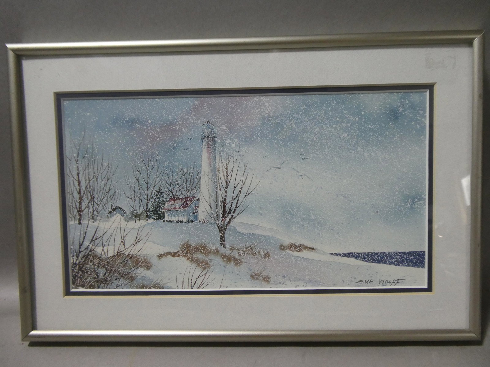 Sue Wolff Signed Lake Michigan Lighthouse Watercolor: Sue Wolff Signed Lake Michigan Lighthouse Watercolor Painting framed under glass. Signed lower right. Measurements in inches: 14 x 9 1/2, image: 11 x 6 Condition:Good with no problems Shipping:We offe