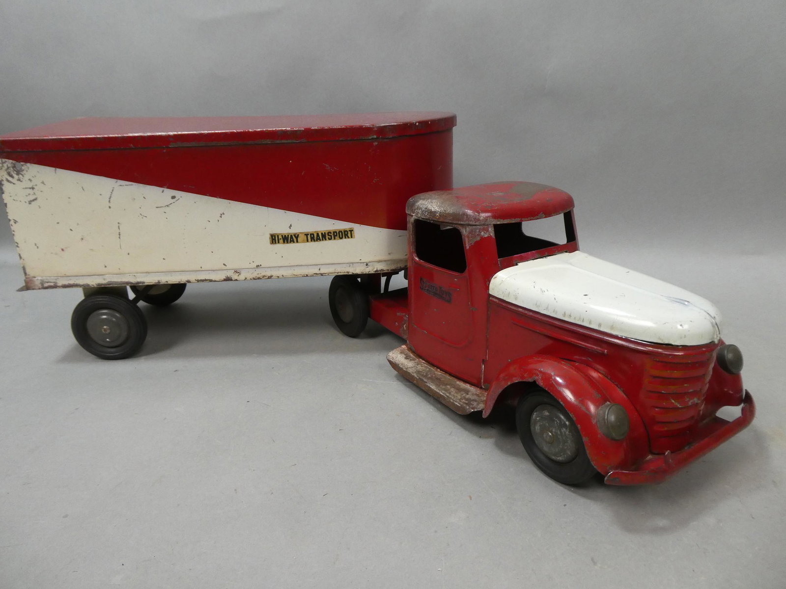 1930's Structo Pressed Steel Hi-Way Transport Truck & Trailer: 1930's Structo Pressed Steel Hi-Way Transport Truck & Trailer. Measurements in inches: 26 long Condition:Has wear and scratch's to original paint, missing back doors Shipping:We offer in-house shippin