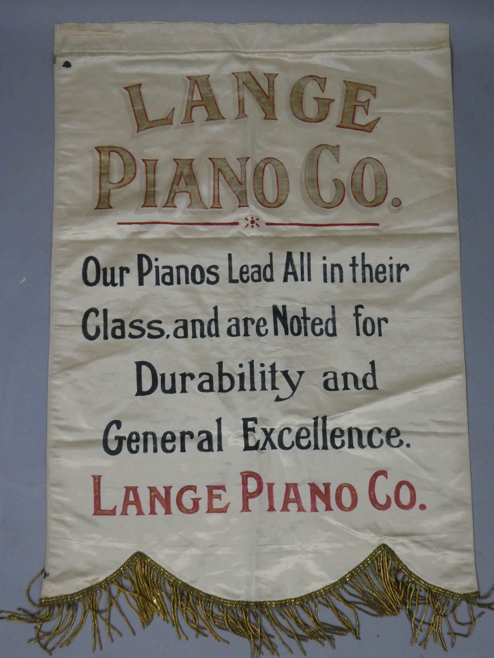Antique Silk Lange Piano Co Hanging Advertising Banner: Antique Silk Lange Piano Co Hanging Advertising Banner. Measurements in inches: 18 x 26 Condition:Has mild wear and stain upper left corner Shipping:We offer in-house shipping. Item(s) will be packed