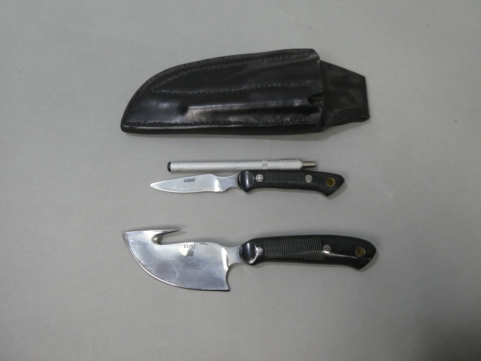 Set 2 Clint Deer Skinning Knife w/ Sharpener & Leather Sheath: Set 2 Clint Deer Skinning Knife w/ Sharpener & Leather Sheath This item is from a Gurnee, IL private estate. The estate included lots of cameras and accessories, motorcycles and parts, vehicles, knive