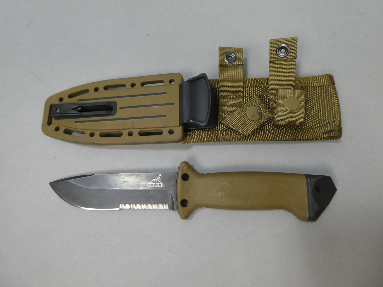 Gerber USA coyote LMF Fixed Blade Tactical combo blade knife & locking sheath: Gerber USA coyote LMF Fixed Blade Tactical combo blade knife & locking sheath This item is from a Gurnee, IL private estate. The estate included lots of cameras and accessories, motorcycles and parts,