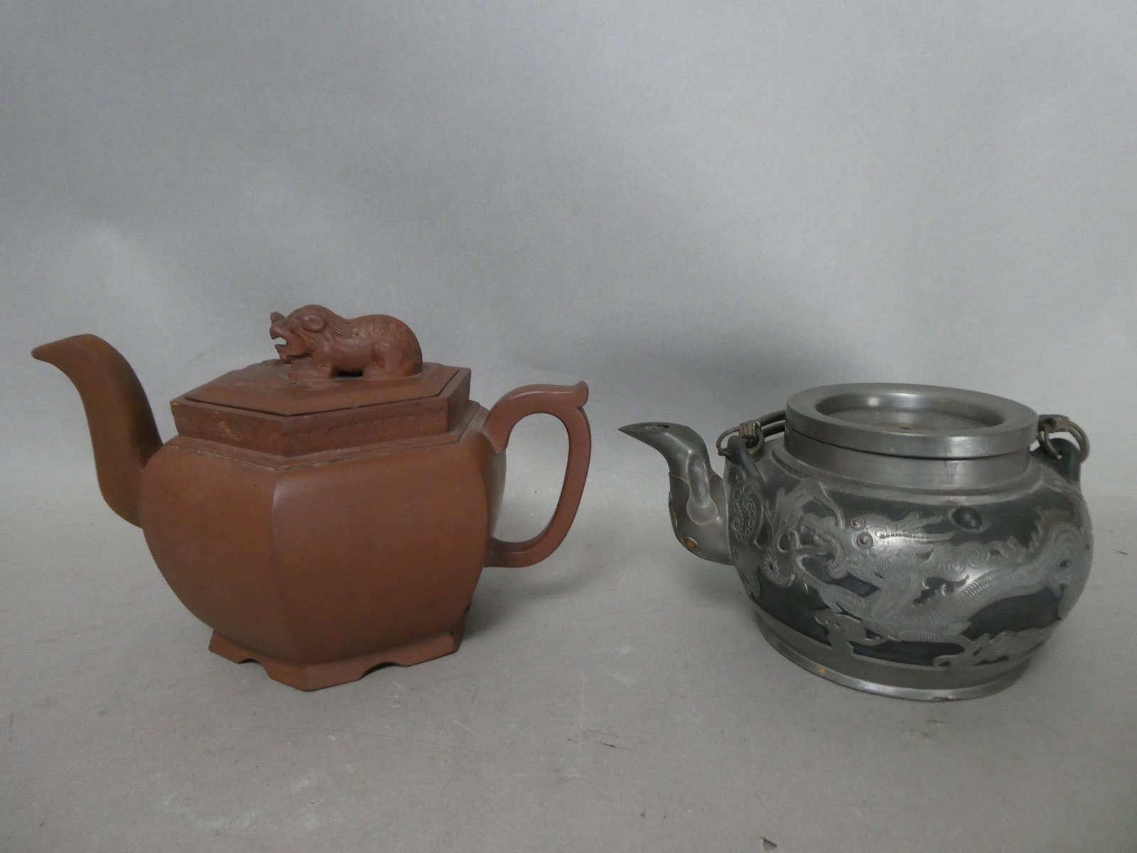 1920-30's Chinese Yixing Teapot clad in Pewter Dragons and Wan symbols: The Yixing potters also worked for other projects like making the teapots for pewter smiths who embellished the clay teapot with designs of dragons and the "wan" symbol signifying unlimited number. Th