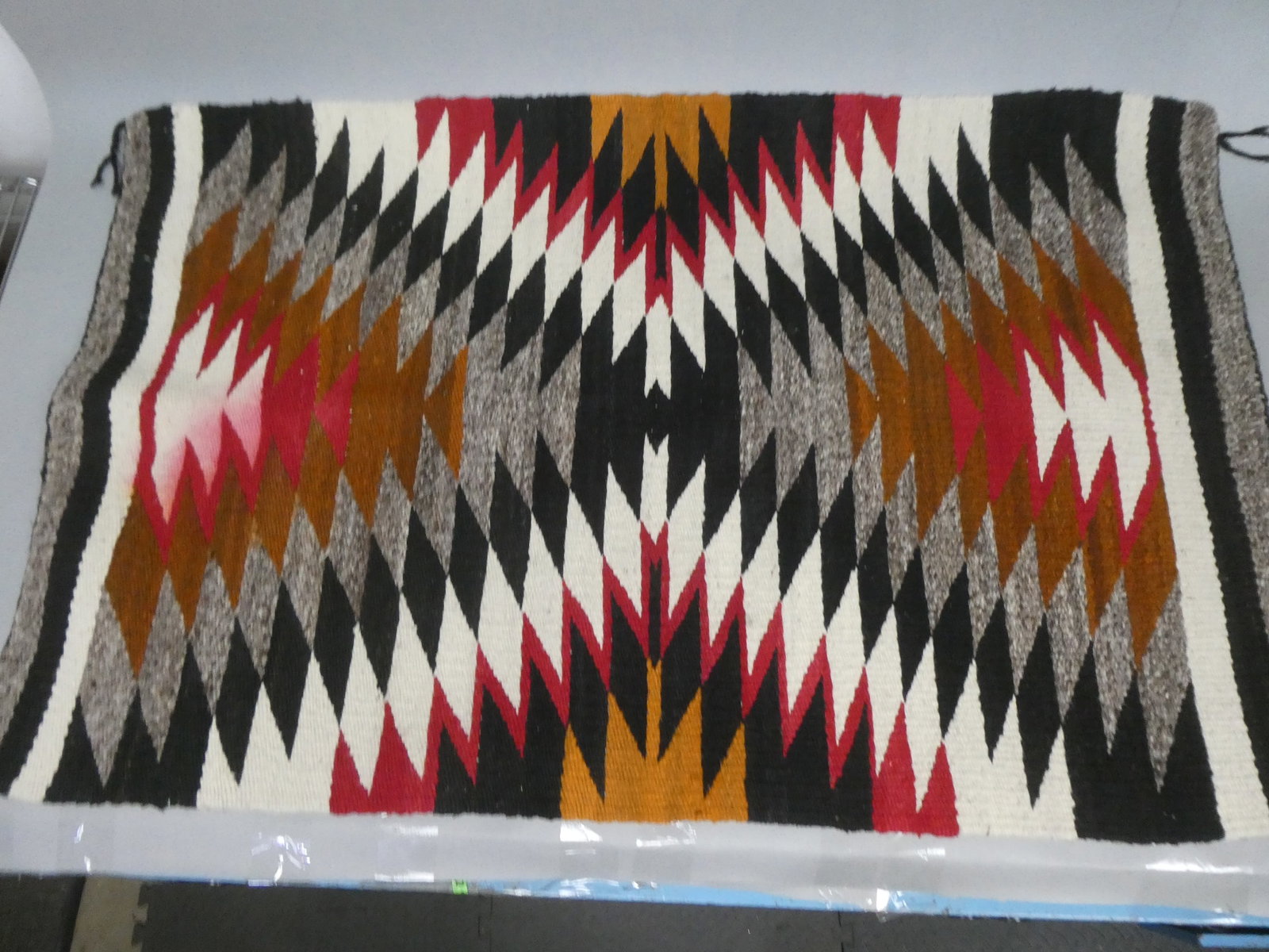 Vintage Native American Navajo Eye Dazzler Rug: Vintage Native American Navajo Eye Dazzler Rug. Measurements in inches: 45 x 29 Condition:Needs cleaning, some red color running on both top and bottom of one side Shipping:We offer in-house shipping.
