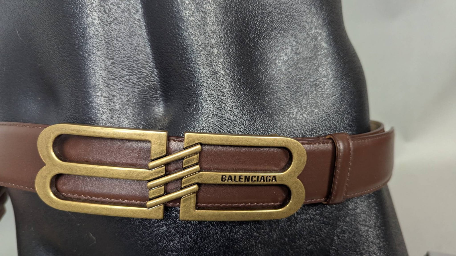 Balenciaga Brown Leather Belt With Brass Buckle: Balenciaga brown leather belt featuring a distinctive brass buckle styled with the iconic double 'B' logo. Measuring 1/2" x 48", this elegant belt is stamped 'Made in Italy' and includes identifying p