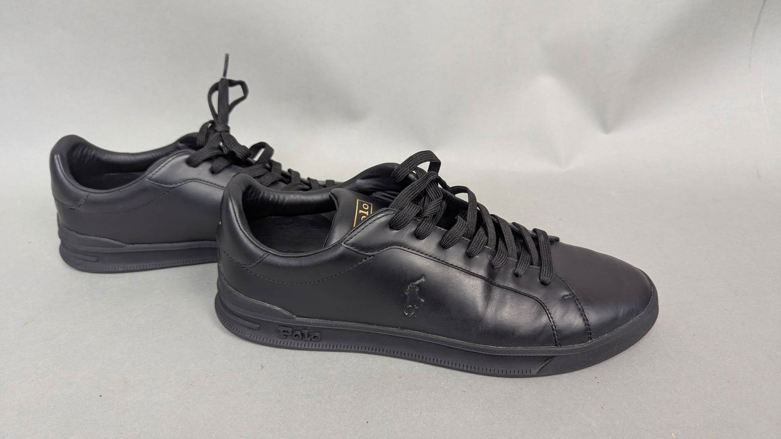 Polo Black Leather Sneakers, Size US 11: Pair of Polo sneakers in black, featuring an upper made of 100% leather with 51% textile lining and a rubber outsole. Size US 11, UK 10, and EUR 44. The sneakers display the Polo logo on the back and