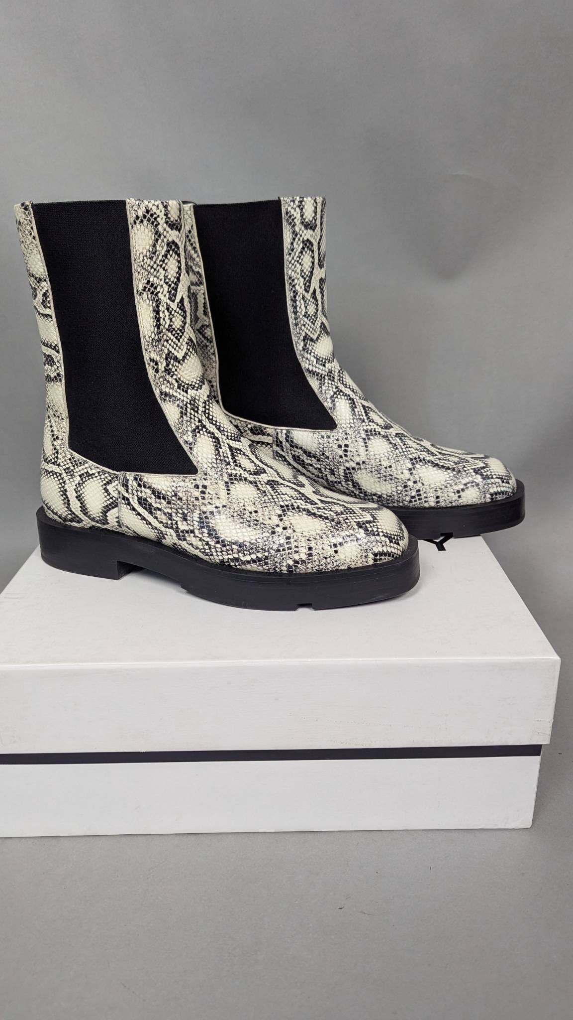 Givenchy Snake-Print Chelsea Boots with Original Box: Givenchy snake-print Chelsea boots featuring a synthetic upper with a snakeskin pattern, black elastic side panels, and a pull tab on the back. Size 42 (EU). The soles feature Givenchy logo detailing,