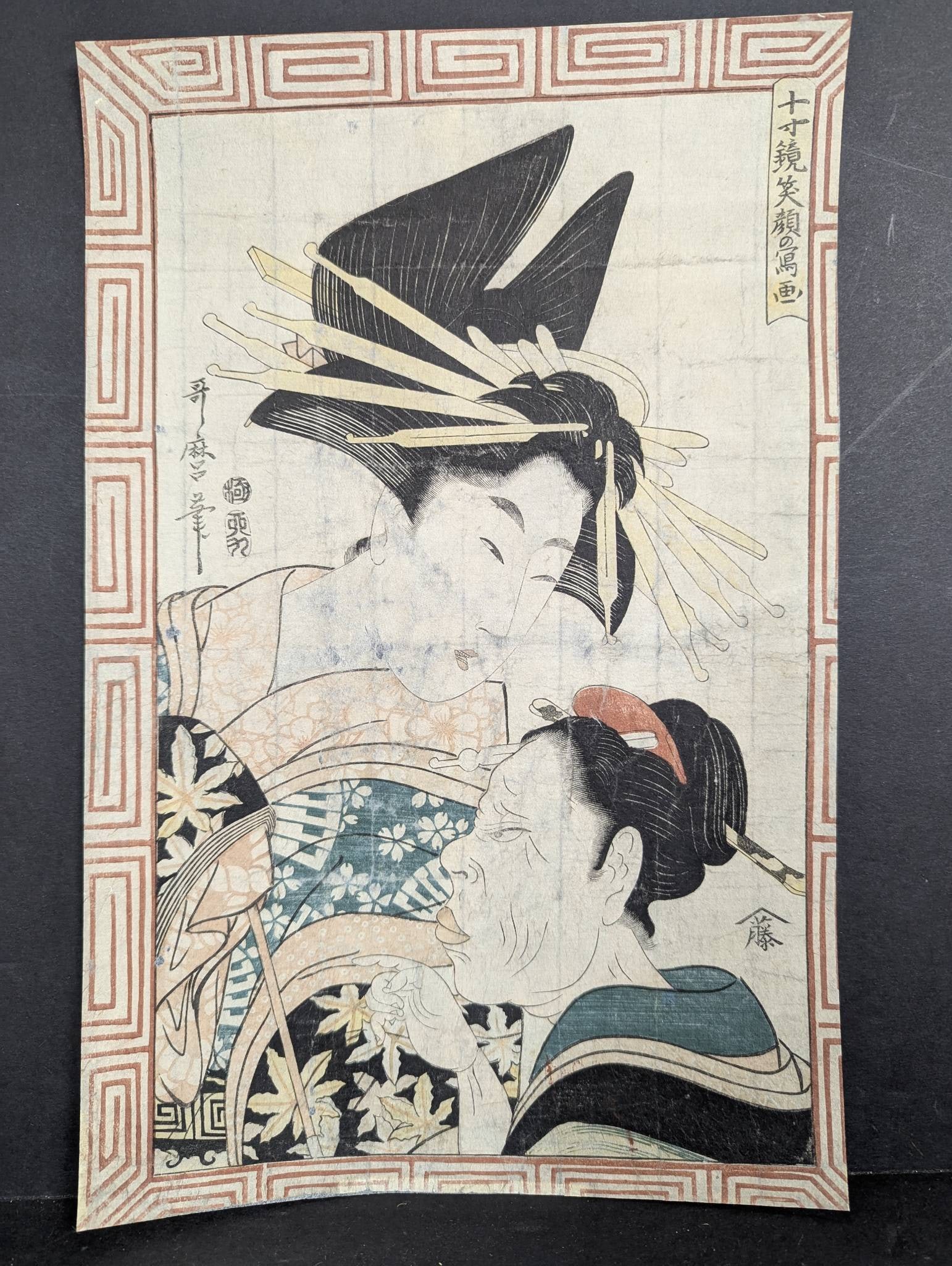 Kitagawa Utamaro II Beauty and her Maidservant 1807 Japanese Woodblock Print: A woodblock print by Kitagawa Utamaro II (1789â€œ1830) titled 'Beauty and her Maidservant' dated 1807. Measuring 9 1/2 x 15 inches this piece shows wear soiling and tape residue on the