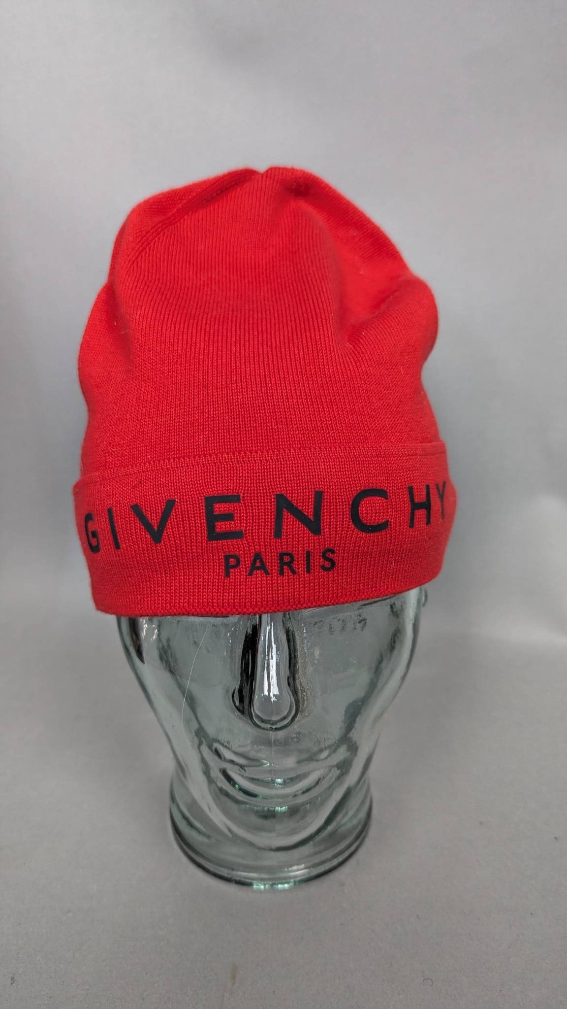 Givenchy Paris Knit Hat in Red with Logo: Givenchy Paris knit hat in a vibrant red hue, featuring the Givenchy logo embroidered in bold black lettering on the fold-over cuff. Made in Italy with a fabric composition of 80% cotton and 15% cashm