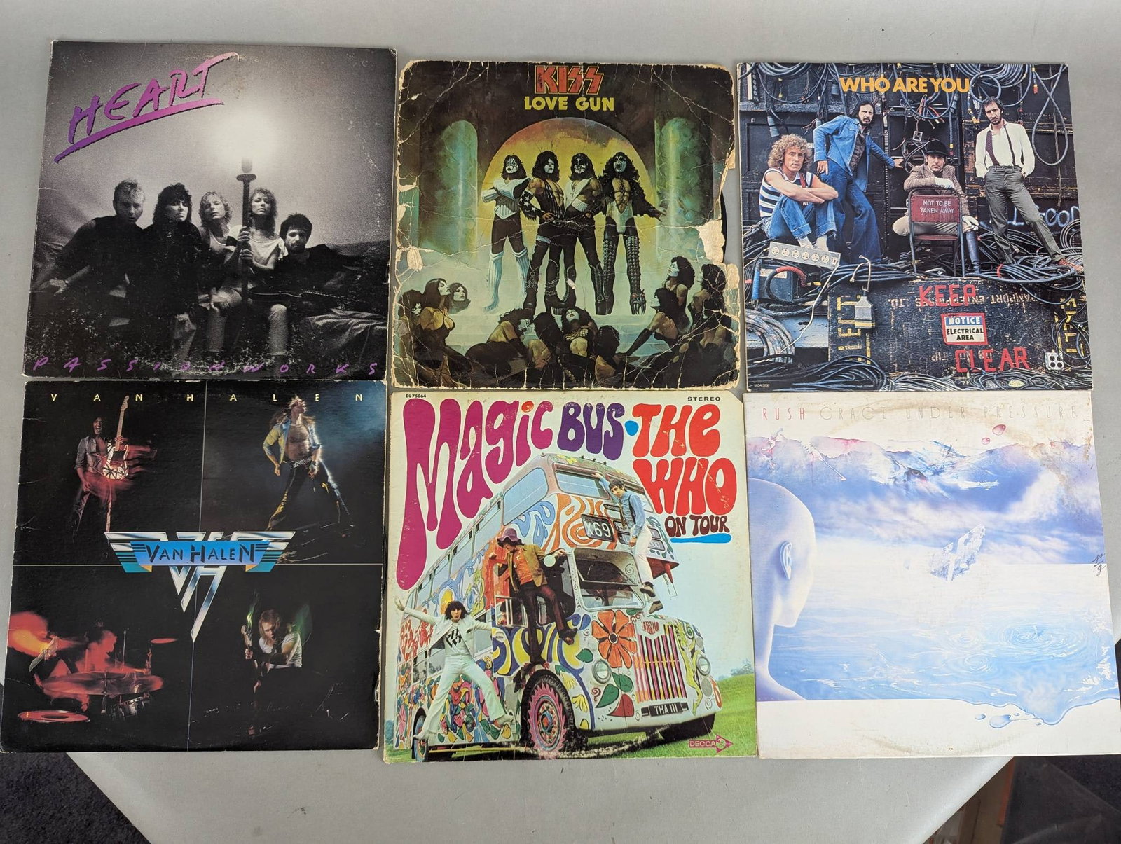 Record Album Lot Featuring Kiss The Who Van Halen Heart and Others: This lot includes a mixed collection of vinyl record albums featuring some popular artists and bands. Titles visible in the lot include Kiss Love Gun, The Who Magic Bus, Van Halen Self-Titled, Heart D
