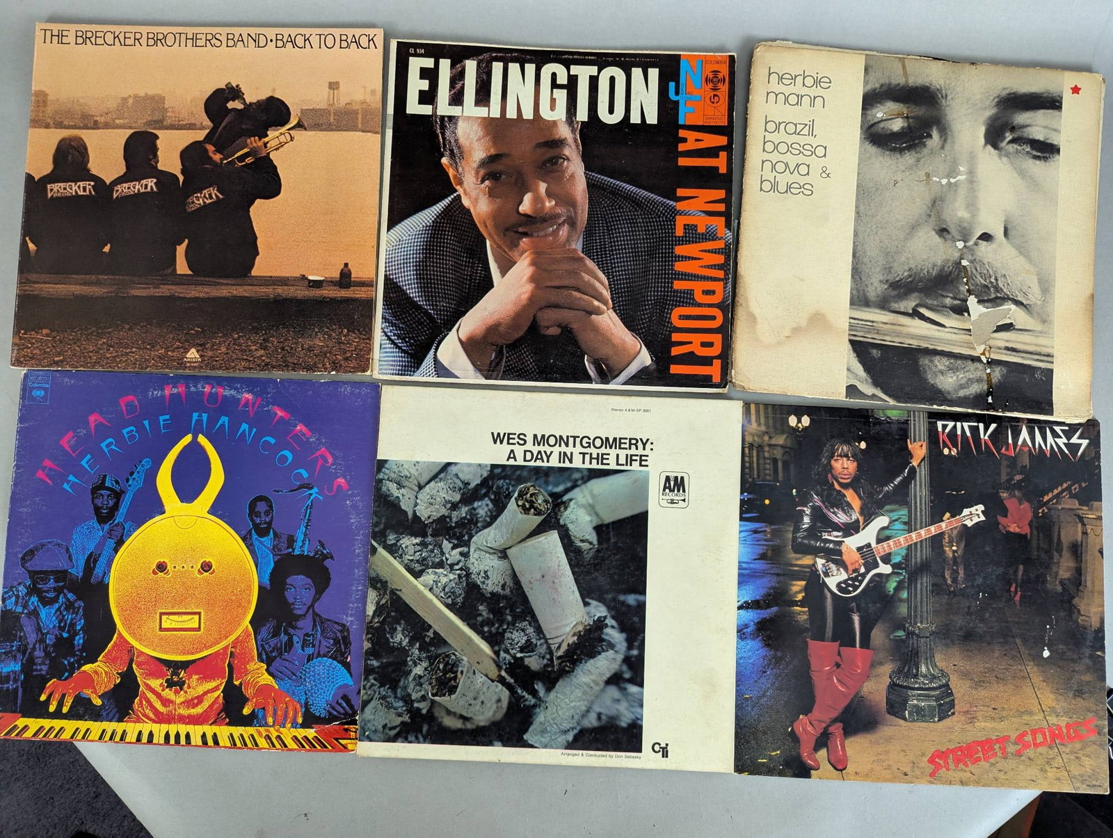 Lot of 11 Record Albums Featuring Jazz and Blues Artists: This lot includes a collection of 11 record albums featuring prominent jazz and blues artists. Titles include The Spinners Pick of the Litter, Duke Ellington At Newport, B B King Live and Well, Wes Mo