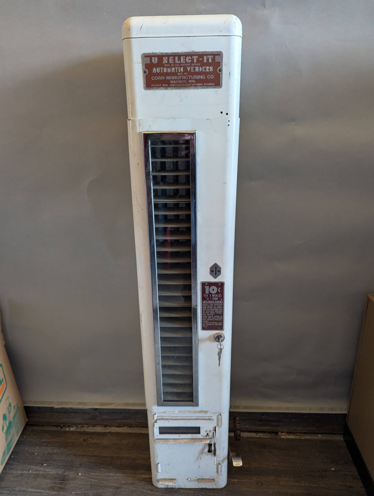 U Select It Automatic Vender by Coan Manufacturing Co: U Select It Automatic Vender manufactured by Coan Manufacturing Co, Madison, Wisconsin. The machine is constructed in a rectangular form standing 48 inches high with a width and depth of 8 x 9 inches.