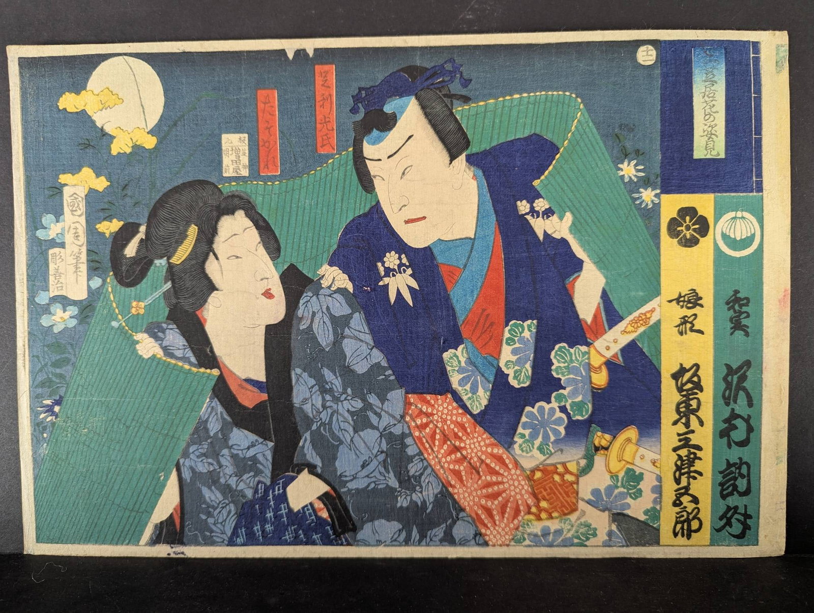 Original Japanese Woodblock Print by Toyohara Kunichika Depicting Kabuki Actors: Japanese woodblock print by Toyohara Kunichika, dating to the 1870s of Kabuki Actors. Measures 14 1/2 by 9 inches. The print features vibrant colors and detailed depictions of two Kabuki actors in tra