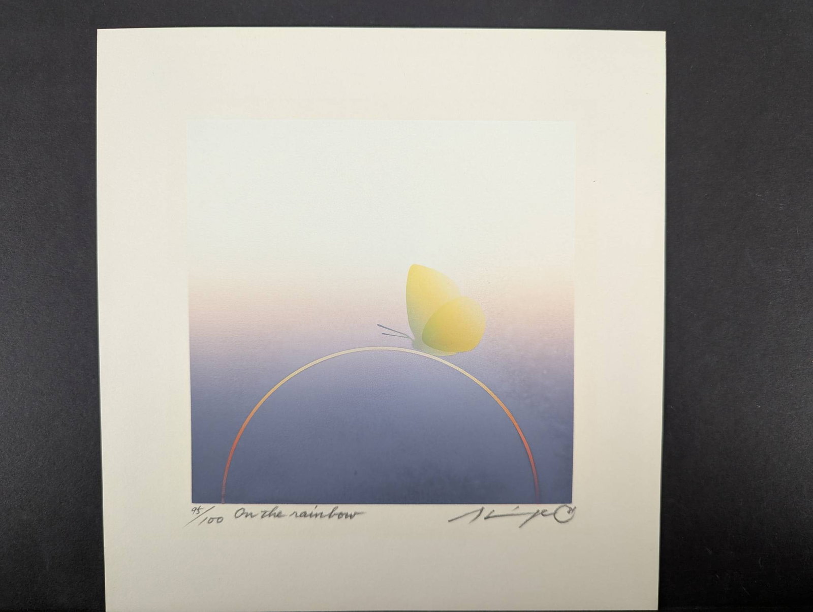 On the Rainbow Limited Edition Serigraph by Okand Konstnar: Limited edition serigraph titled On the Rainbow by Okand Konstnar. Numbered 95 out of 100 and dated 1981. Features a minimalist composition with a yellow butterfly perched on a curved line against a g