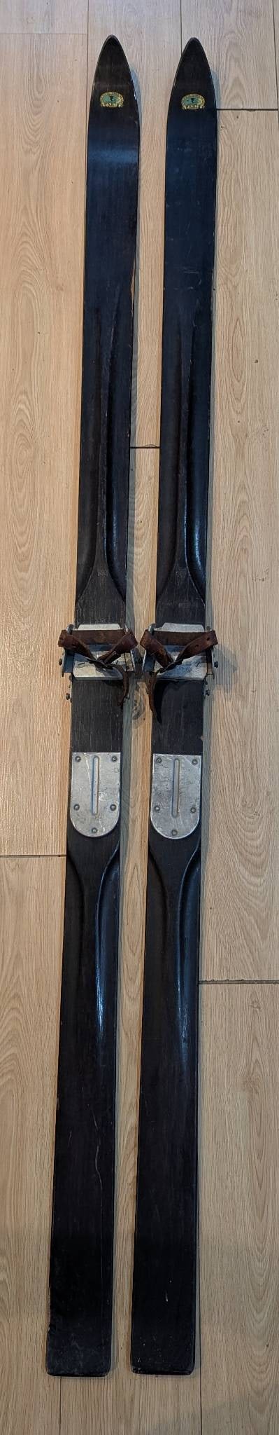 Paris Manufacturing Co Wooden Skis 74 Inches Long with Bindings: Pair of 74-inch-long wooden skis produced by Paris Manufacturing Company of South Paris, Maine, USA. Identifiable by the painted decal and embossed marking that read Paris Mfg Co South Paris Maine. Eq