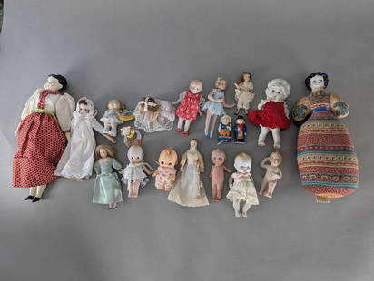 Collection of Vintage Dolls in Ceramic & Bisque Various Styles Kewpie etc: A collection of vintage dolls featuring an assortment of designs and materials. The group includes ceramic, bisque, and plastic dolls, some dressed in detailed clothing such as lace outfits, period-st