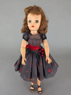 Ideal Miss Revlon Doll in Cherries a la Mode Dress: Ideal Miss Revlon doll VT-18. The doll is 18 high x 7 wide x 3 deep with rooted hair styled in loose curls, painted features, and movable arms and legs. It is dressed in a Cherries a la Mode outfit