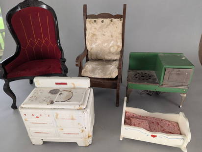 Collection of Vintage Toy Furniture with Rocking Cradle Stoves etc: Lot of vintage toy furniture consisting of five items. Includes a white-painted toy stove with red detailing and visible wear from age; a green-painted cast metal toy cookstove with surface rust and