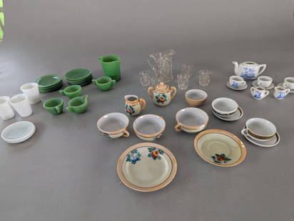 Collection of Doll or Childs Dishes with Various Designs Jadeite etc: A mixed collection of doll or child's dishes featuring various materials and patterns. The lot includes ceramic miniature dishes with floral and gold-tone designs, a set of white ceramic items with