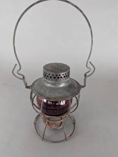 Penn Central Railroad Dressel Lantern with Red Globe: Penn Central Railroad lantern manufactured by Dressel of Arlington, NJ. The lantern body is constructed of metal with a vented top and a protective wire guard frame. The red globe is intact though it