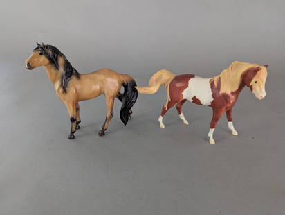Breyer Set of 2 Horse Figurines with Paint and Buckskin Patterns: Set of two Breyer horse figurines, each crafted in durable plastic. The first figurine features a paint pattern with brown and white markings and blonde mane and tail. The second figurine depicts a