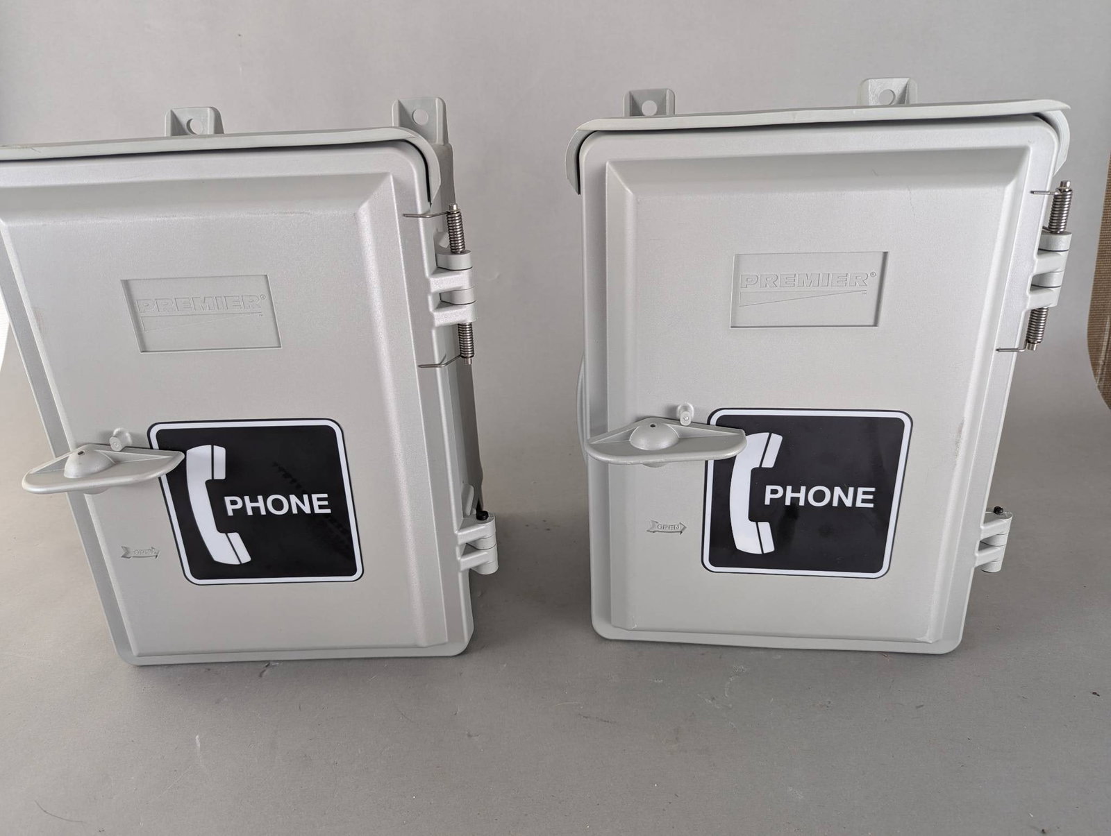 Two Premier PT-9700 Industrial Telephone Enclosures with 630A Wall Jacks: Two Premier PT-9700 industrial telephone enclosures, manufactured in 2008. Each enclosure includes a 630A wall jack and measures 15 high x 10 wide x 11 deep inches. Made from durable materials, these 