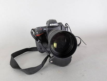 Nikon D2x Camera With AF Nikkor 180mm f2.8 D Lens: Nikon D2x digital camera paired with an AF Nikkor 180mm f2.8 D lens. The lens is clean, and the camera successfully powers on and performs a test photo take. No further testing conducted. Includes a B