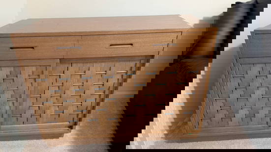 Edward Wormley for Dunbar Woven Front Sideboard in Oak: Edward Wormley-designed sideboard for Dunbar featuring a woven front design with sliding panels. Constructed in oak with integrated wooden handles, the sideboard includes two upper drawers, one of whi