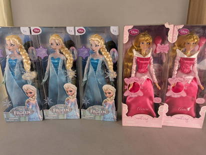 5 Disney Singing Dolls Featuring Frozen Elsa and Aurora New: Five Disney singing dolls in original packaging. Three dolls represent Elsa from the movie Frozen, featuring intricate detailing on her blue sparkly dress and long braided blonde hair. The dolls are l