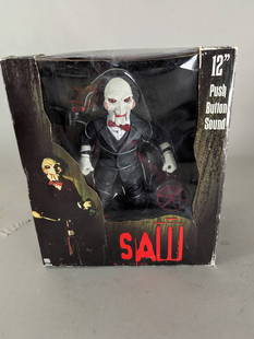 NECA 12 Inch Saw Figure with Push Button Sound Feature New: NECA collectible figure from the Saw franchise. Stands 12 inches tall and features a push-button sound mechanism. Still in the original packaging, which measures approximately 12 high x 13 wide x 8 de