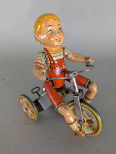 Unique Art Kiddy Cyclist Tin Wind Up Tricycle Toy: Tin lithograph wind-up toy produced by Unique Art MFG Co depicting a child in striped attire riding a tricycle. The toy features a bright multi-colored design with illustrations on the wheels showcasi
