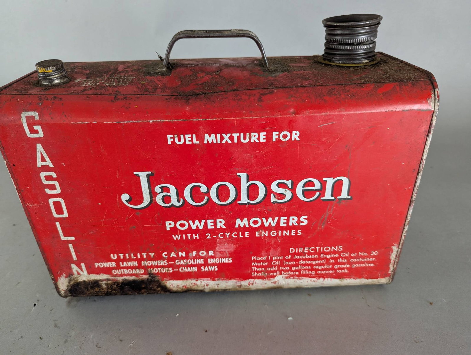 Jacobsen Gasoline Can for Power Mowers with 2 Cycle Engines: Jacobsen branded metal gasoline can designed for use with power mowers and 2-cycle engines. The can features a red body with white text reading Jacobsen Power Mowers and Fuel Mixture for Gasoline. Add