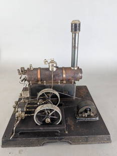 Wurttemberg Steam Engine Toy Machine Set: Wurttemberg steam engine toy constructed with a metal boiler, copper detailing, and a base plate. Features include a chimney piece, two pistons, a flywheel, and a generator or dynamo assembly at the r