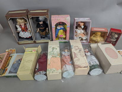 Collectible Dolls in Original Boxes Including Storybook and Holiday Themes: Lot of 12 featuring a collection of various collectible dolls, each housed in its original box. Included are dolls with themes such as nursery rhyme characters, historical figures, and holiday decorat