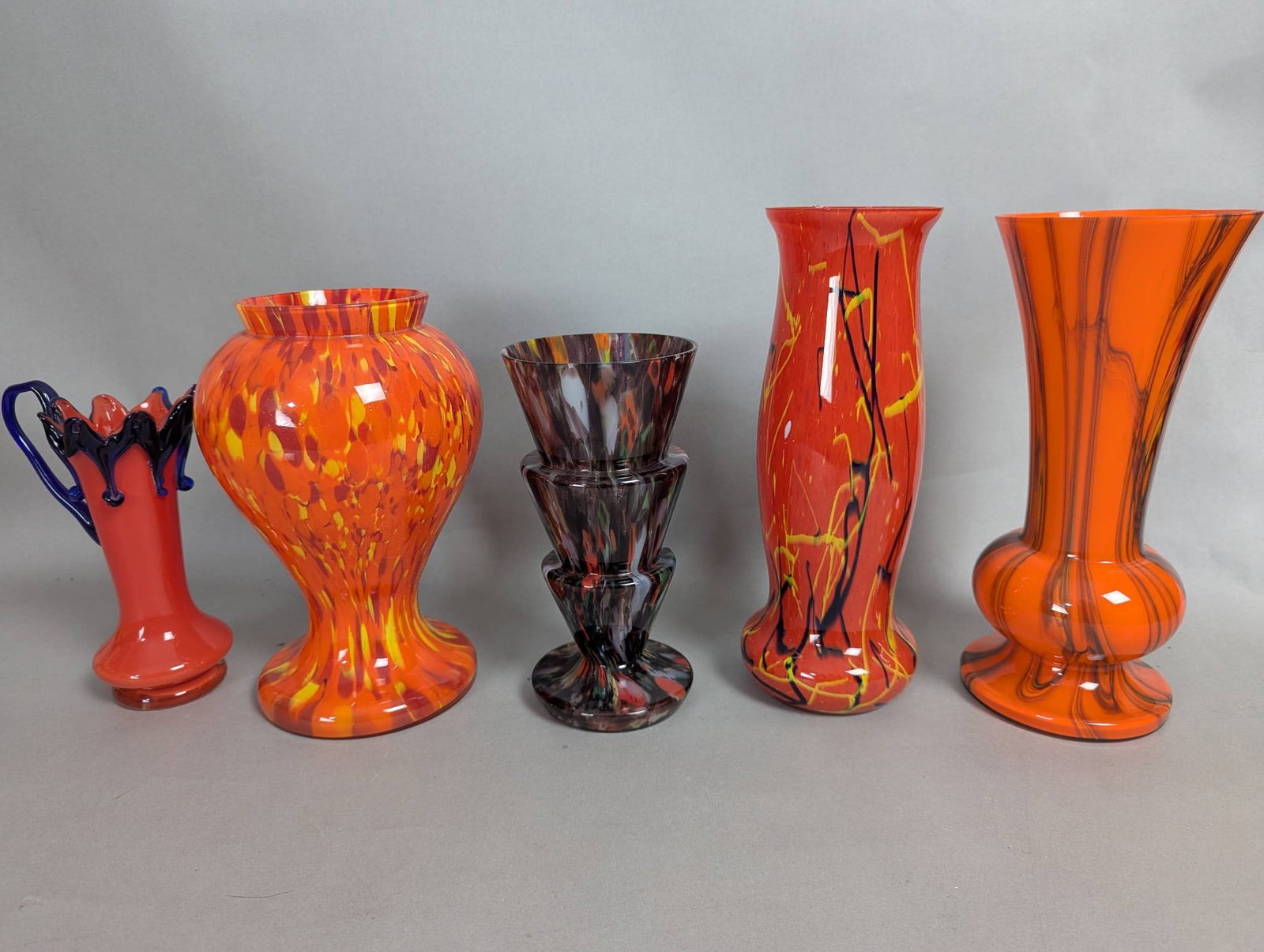5 Hand Blown Czech Glass Vases in Various Patterns: 5 hand blown Czech glass vases, showcasing a variety of vibrant patterns and hues. The tallest vase measures 12 inches in height, with base dimensions of 5 inches in width and depth. The collection in