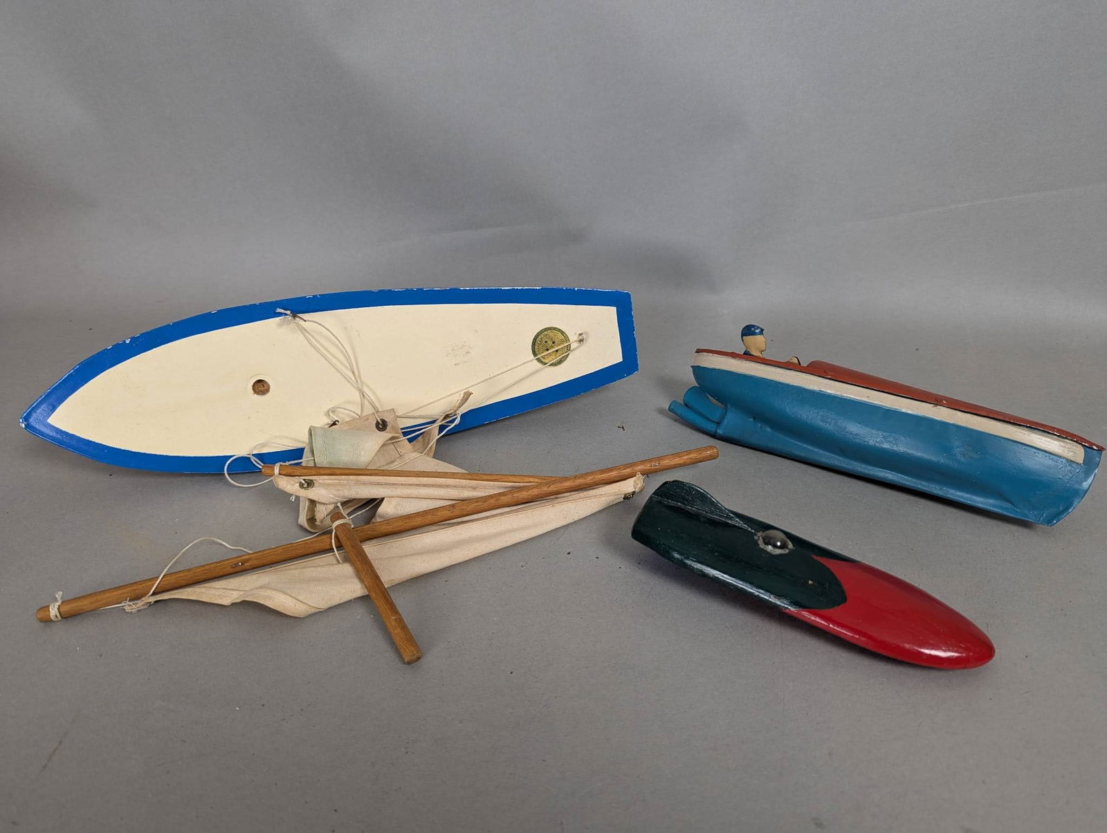 3 Vintage Wood and Tin Toy Boats: 3 vintage toy boats made of wood and tin. The largest boat measures 15 high x 5 wide x 4 deep and features a sail and rigging, with a label indicating it was constructed to Australian Standards. The s