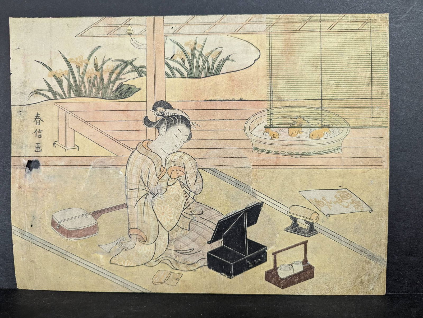 Japanese Woodblock Print by Suzuki Harunobu with Shamisen and Mirror: Japanese woodblock print by Suzuki Harunobu (1724-1770), titled Beauty Seated in a Room with Shamisen before Mirror. Harunobu was a renowned Edo-period artist best known for pioneering full-color wood