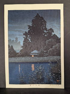 Japanese Woodblock Print Night Rain at Omiya by Kawase Hasui: Japanese woodblock print titled Night Rain at Omiya (also known as Rain at Omiya) by Kawase Hasui (1883-1957), a prominent artist of the Shin-hanga movement. The print showcases a rural village in Omi